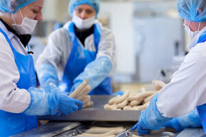 Metzger bei der Wurstherstellung in der DAMHUS-Produktion